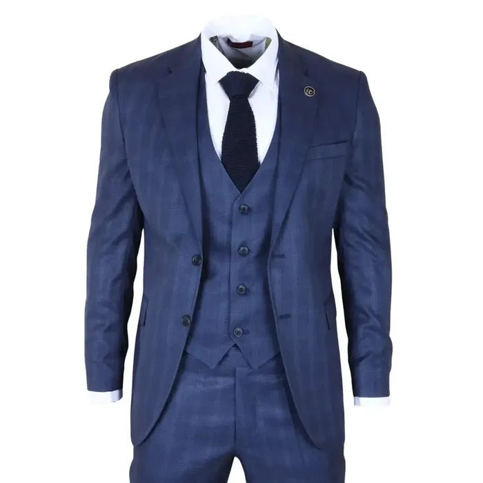 Men's navy blue tailored fit suit with subtle check pattern, featuring a single-breasted blazer, matching trousers, and a white shirt with a navy knitted tie.