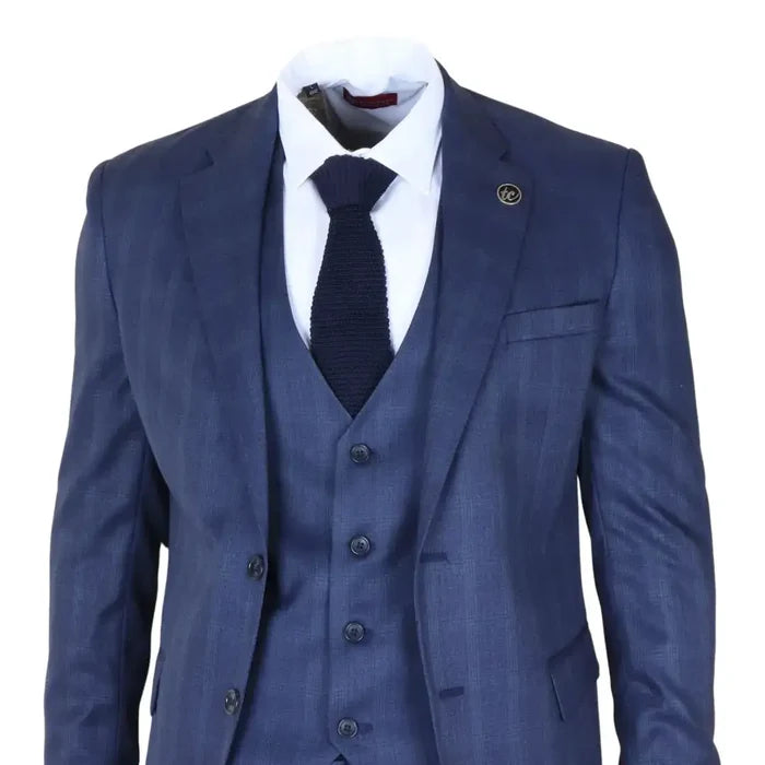 Close-up of men's navy blue check suit blazer with a lapel pin, white shirt, and navy knitted tie, highlighting the tailored fit and pattern.