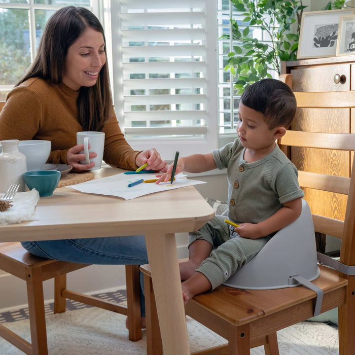 Grey Ingenuity My Spot Easy-Clean baby booster seat with 3-point harness attached to dining chair