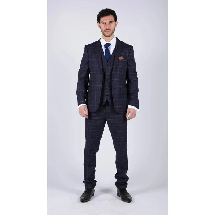 Male model wearing navy blue checkered suit with blazer, waistcoat, trousers, white shirt, and blue tie, formal business attire