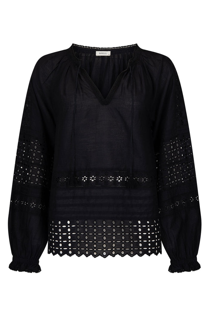 Black blouse flat lay showing schiffli anglaise hem, blouson sleeves, elasticated cuffs, and front tie with tassels