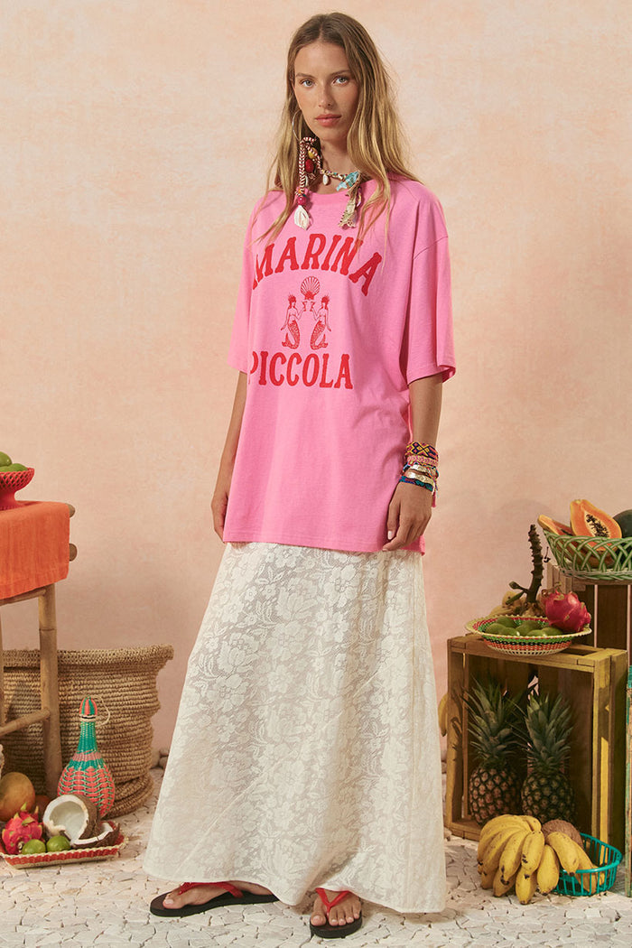 Front view of oversized cosmos pink Marina Piccola graphic tee styled with white lace maxi skirt