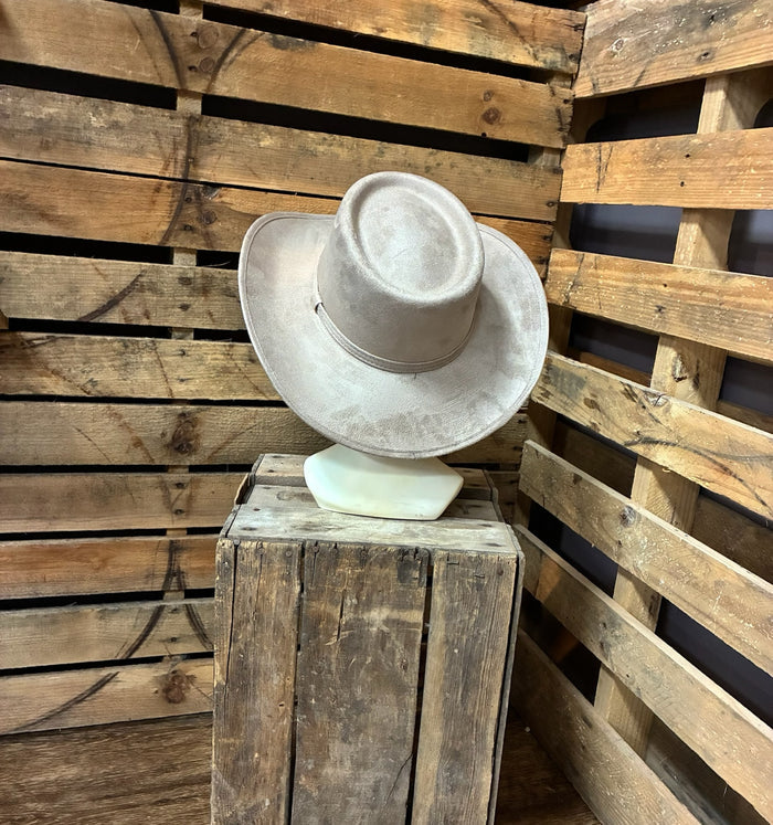 White cowboy hat on a wooden stand against a wooden slat background