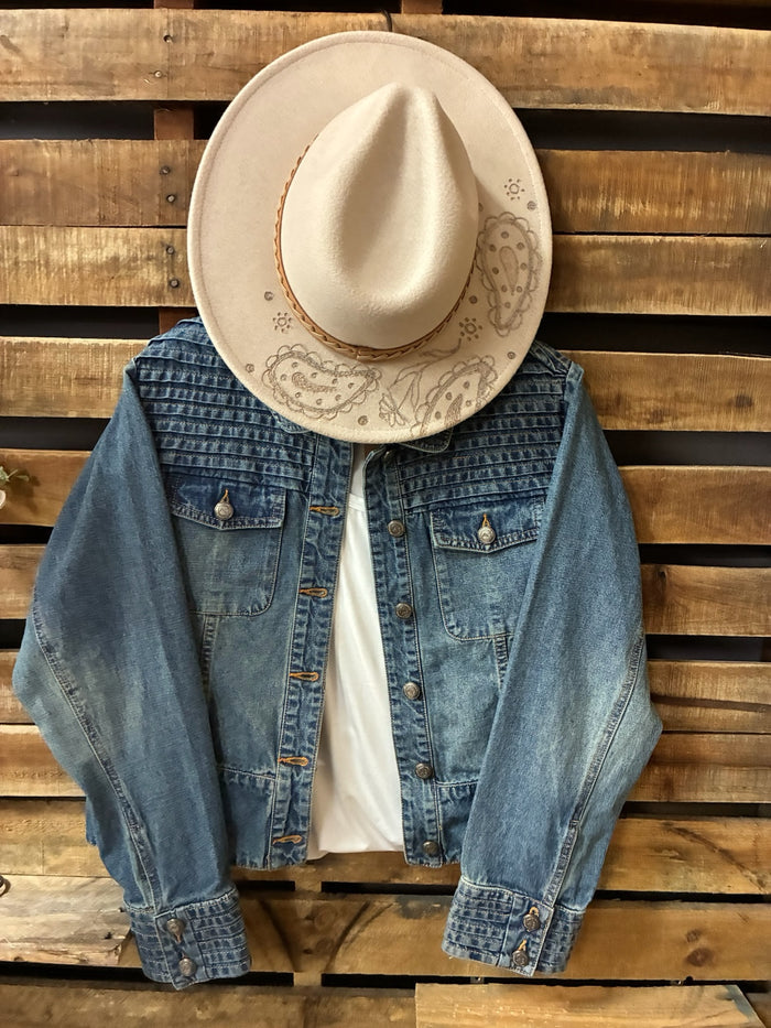 Denim jacket and cowboy hat on a wooden pallet