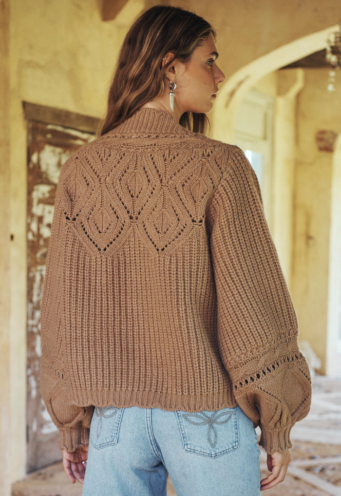 Back view of a model wearing Mulberry Knit Cardigan, showing openwork leaf pattern and blouson sleeves