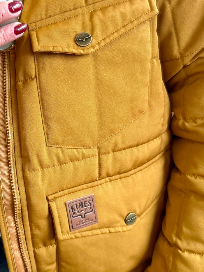 Mustard quilted coat chest pocket with logo patch and metal snap button