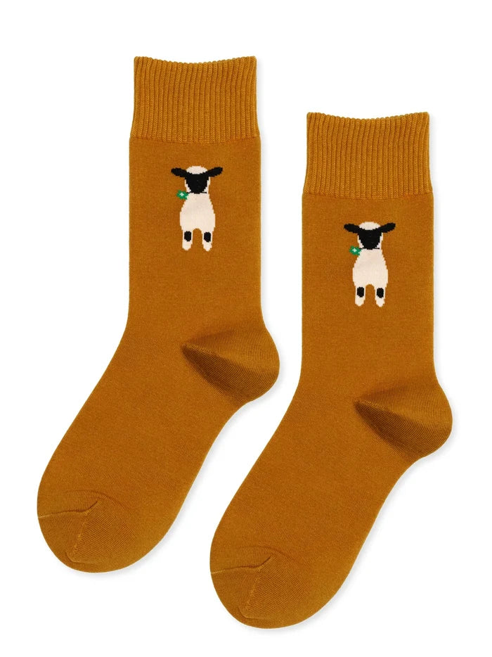 Nice to See Ewe Crew socks in Ochre — warm golden ochre cotton crew with white and black lamb motif holding a green flower, flat lay product shot on white background