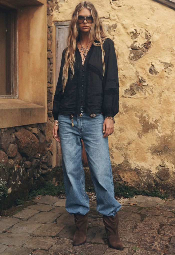 Front view of chocolate suede slouch ankle boots styled with wide-leg jeans and brown knee-high boots