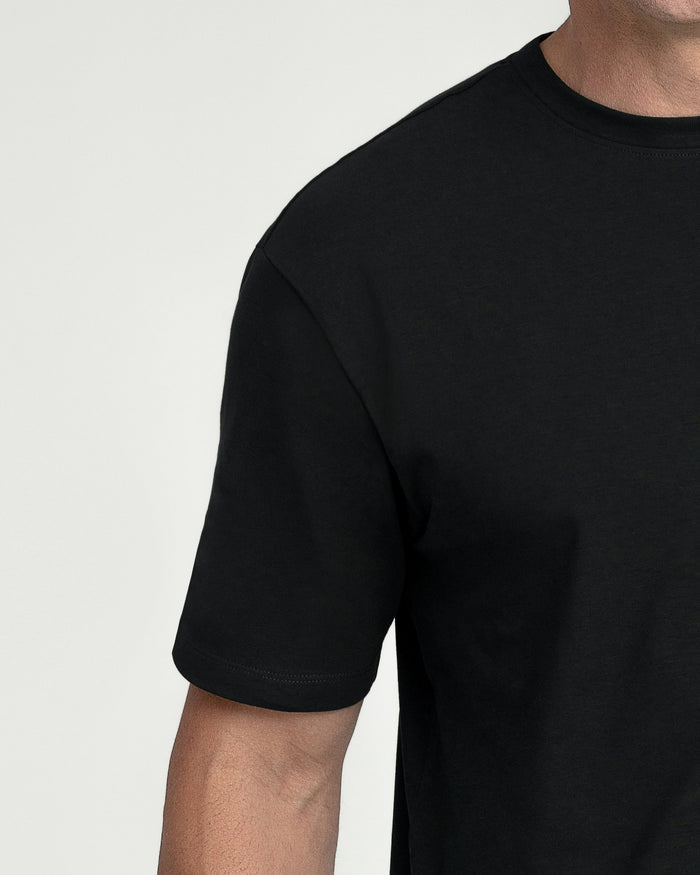 Man wearing black crew neck t-shirt with short sleeves and fitted cut.
