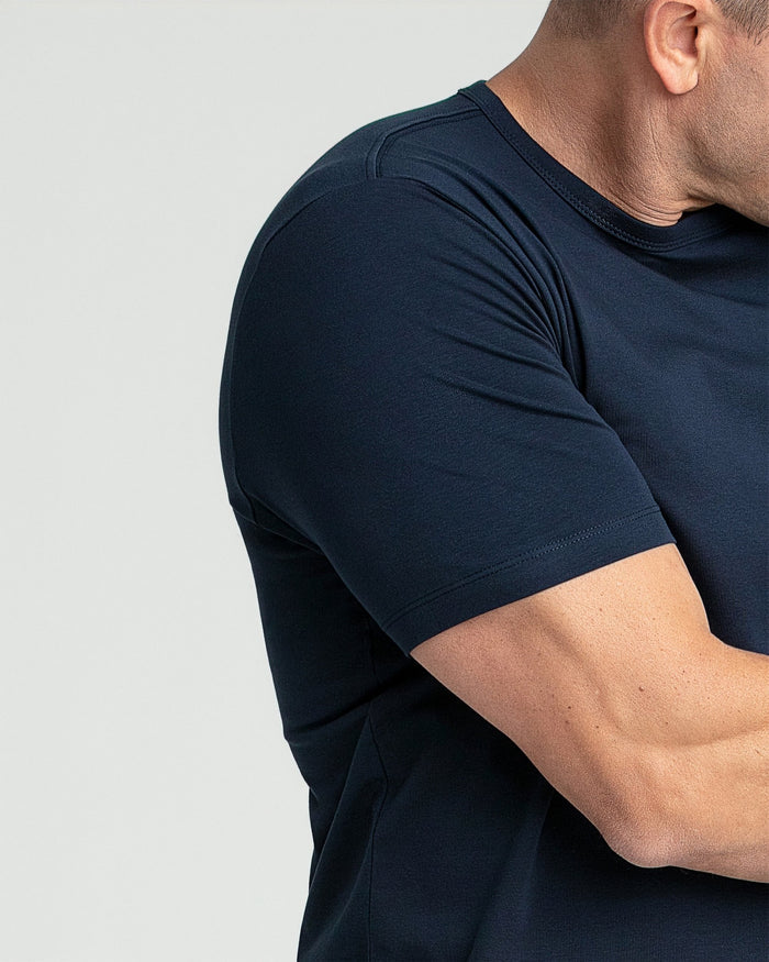 Navy crew neck t-shirt with short sleeves shown on a man from shoulder to waist.