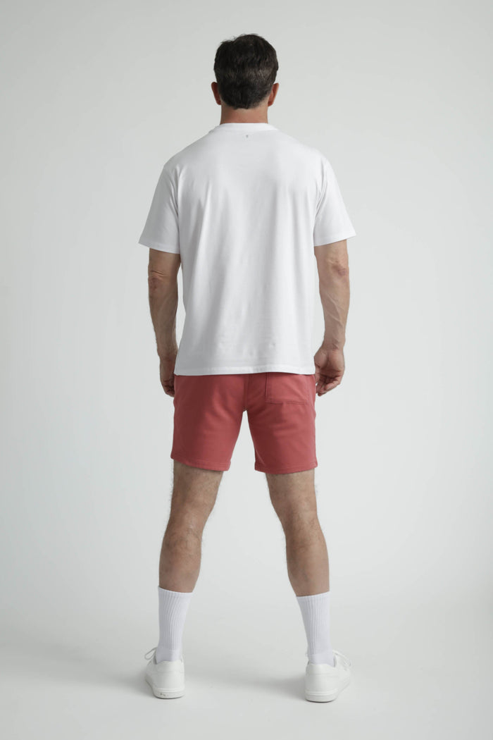 Man wearing white crew neck t-shirt with short sleeves, shown from back view.