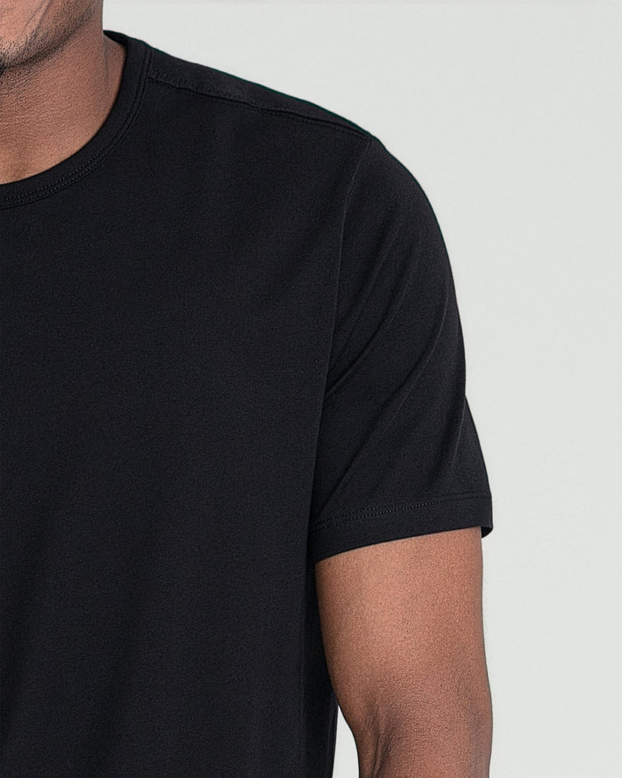Black crew neck t-shirt with short sleeves worn by male model, front detail view.