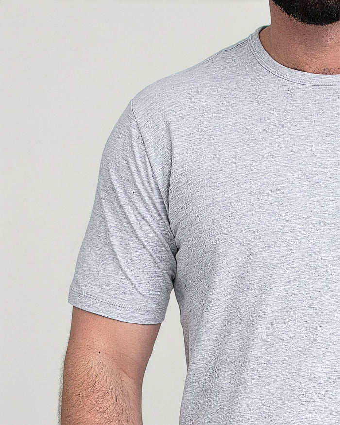 Heather grey crew neck t-shirt with short sleeves worn by a model against a neutral background.