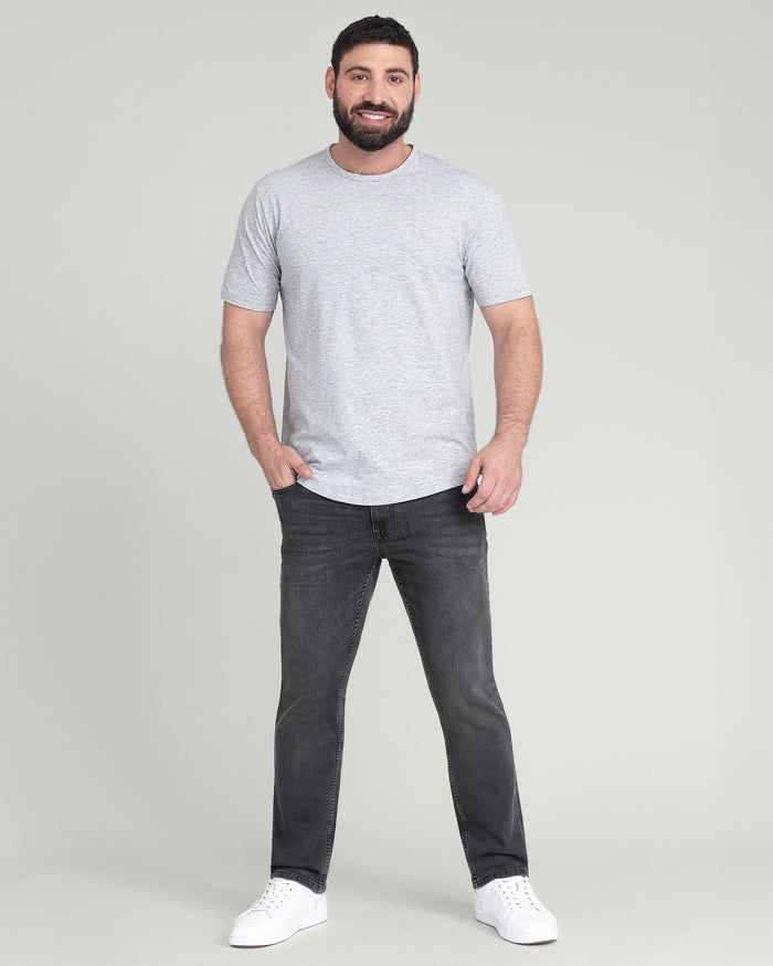 Man wearing heather grey crew neck t-shirt with short sleeves and dark jeans.