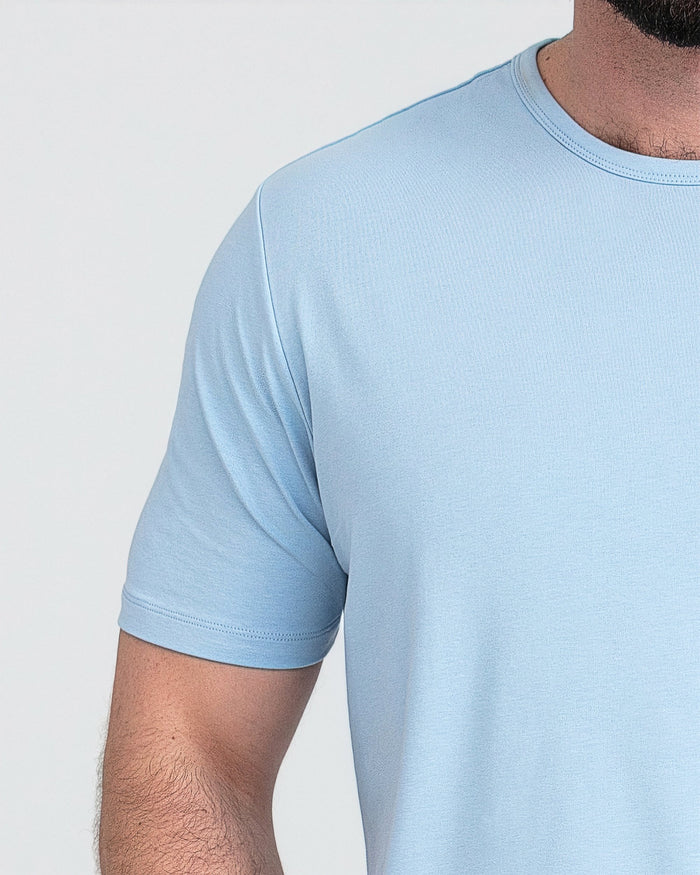 Light blue crew neck t-shirt with short sleeves worn by a man against a white background.