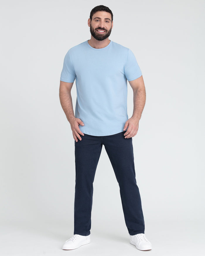 Man wearing light blue crew neck t-shirt with short sleeves and dark navy pants.