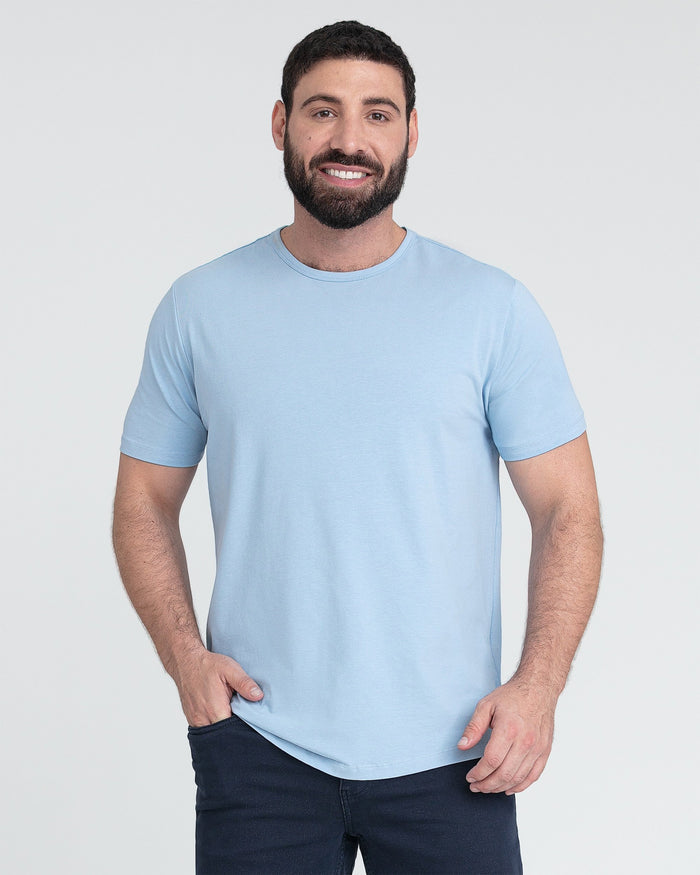 Man wearing light blue crew neck t-shirt with short sleeves and dark navy pants.