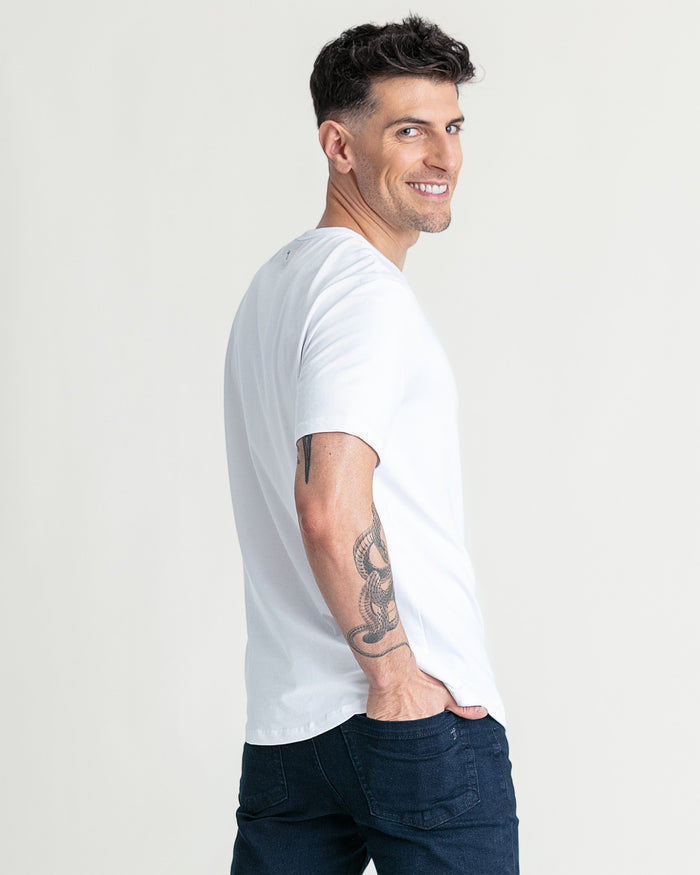 White crew neck t-shirt with short sleeves on a man wearing dark jeans.