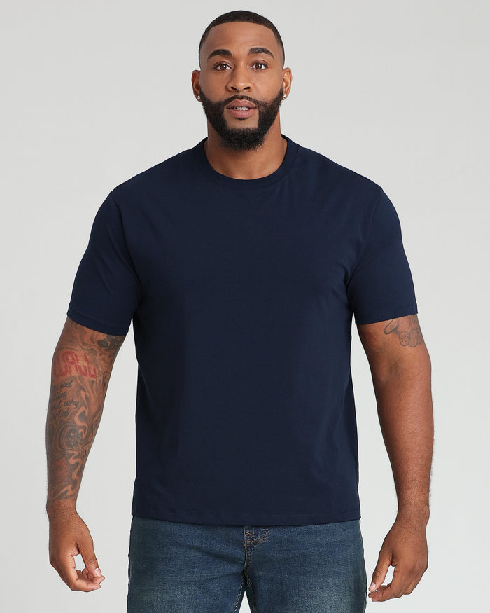 Man wearing navy crew neck t-shirt with short sleeves and blue jeans.