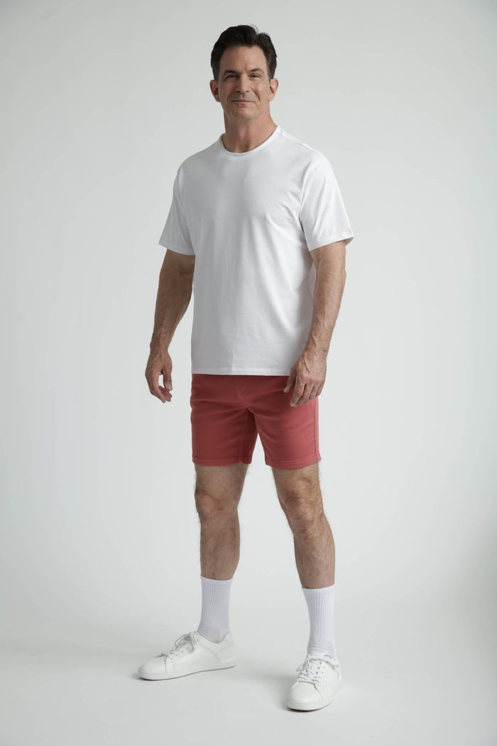Man wearing white crew neck t-shirt with short sleeves and fitted silhouette.
