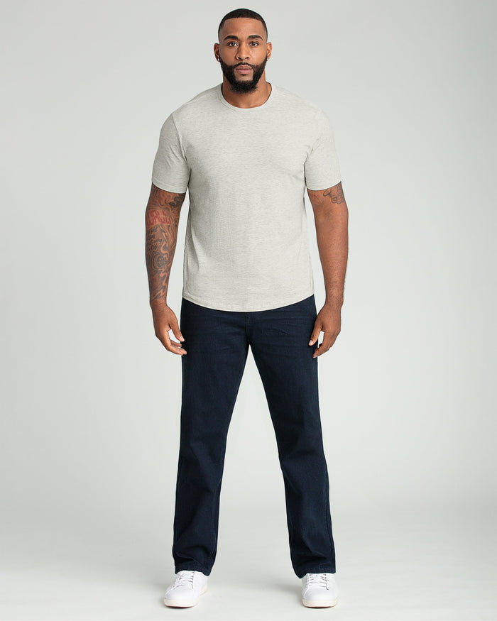 Man wearing oatmeal heather crew neck t-shirt with short sleeves and dark jeans.