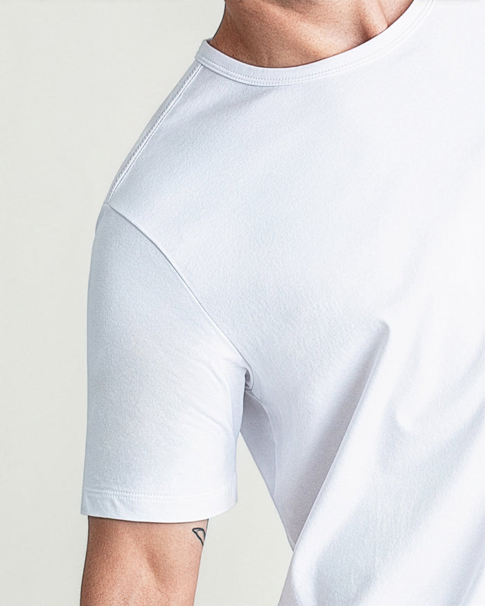 White crew neck t-shirt with short sleeves shown on male model against neutral background.