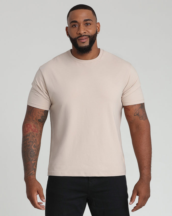 Tan crew neck t-shirt with short sleeves on a man wearing black pants.