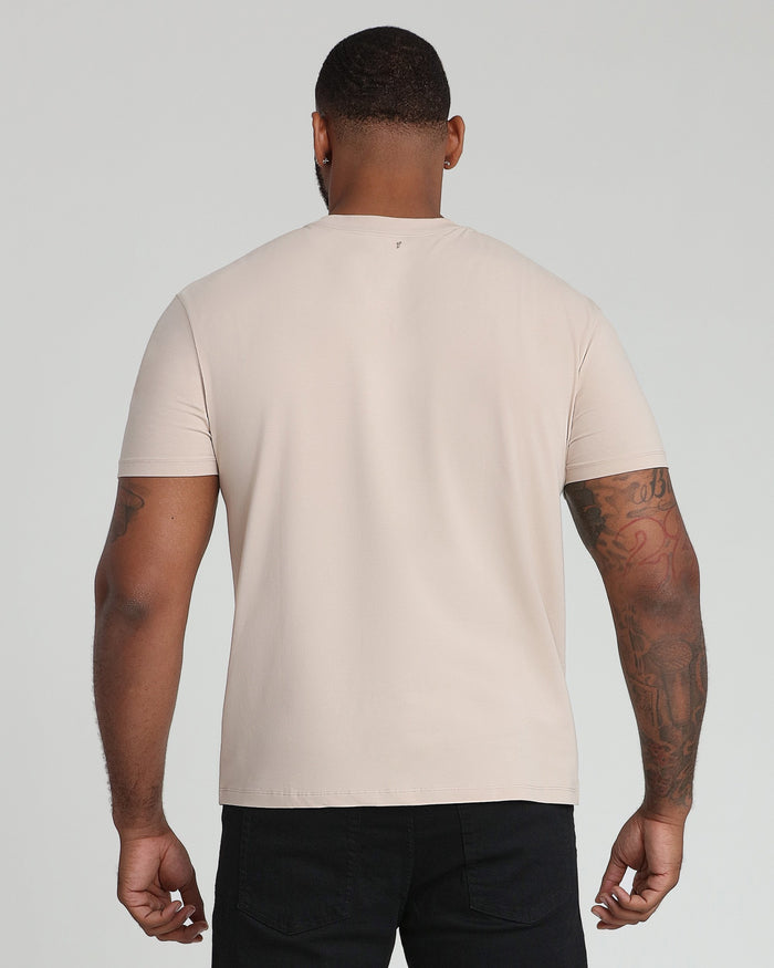 Tan crew neck t-shirt with short sleeves shown on a man wearing black pants, back view.