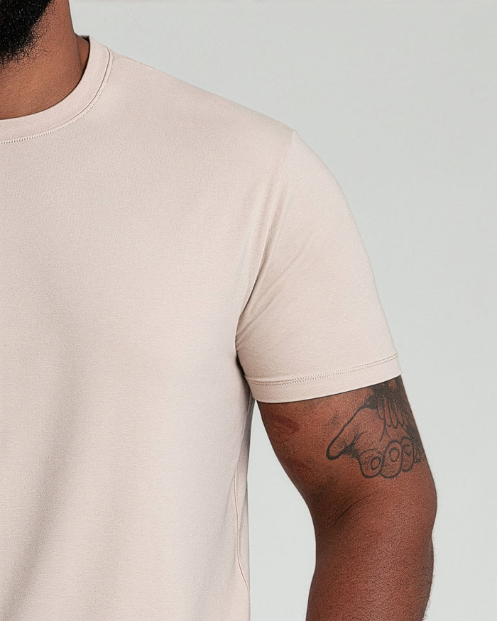 Tan crew neck t-shirt with short sleeves, shown on a model from shoulder to mid-torso.
