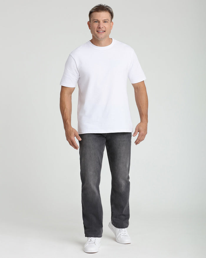 White crew neck t-shirt with short sleeves on male model wearing dark jeans.