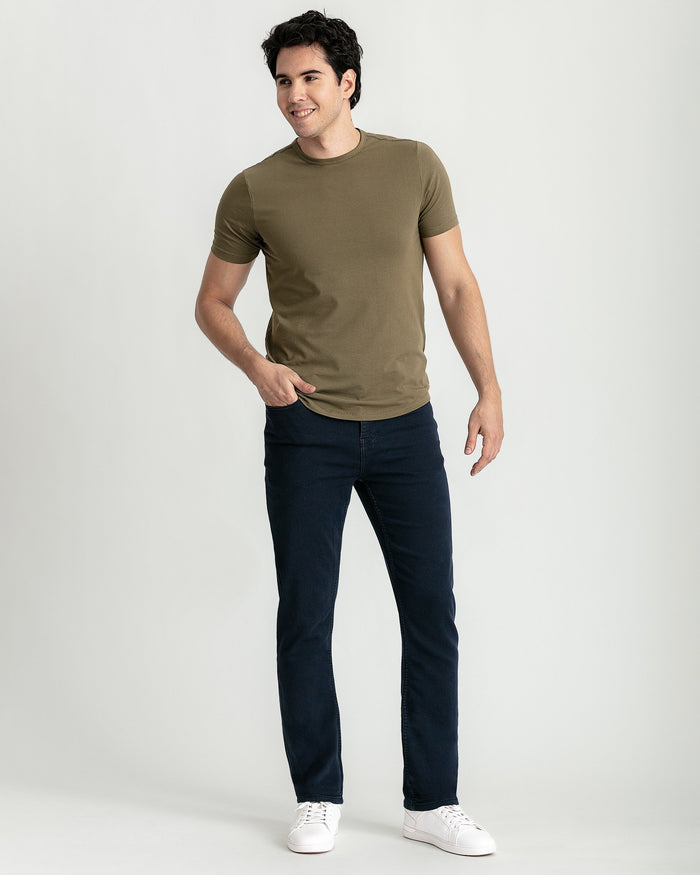 Man wearing military olive crew neck t-shirt with short sleeves and dark jeans.