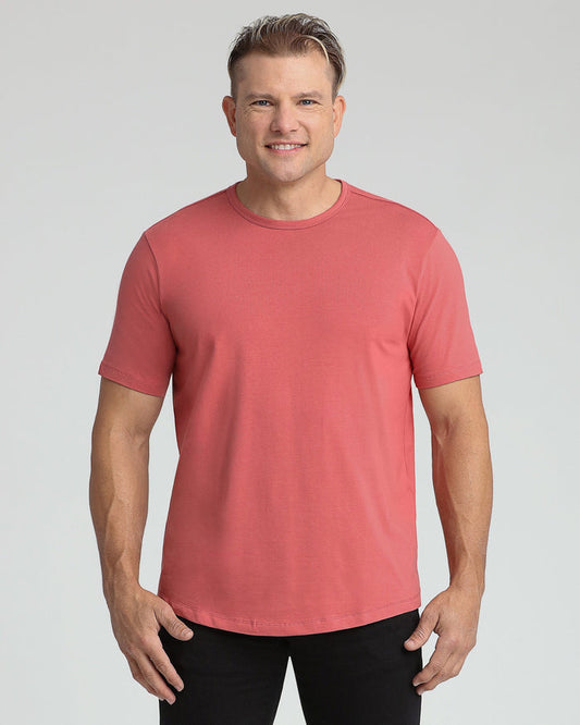 Man wearing a coral-red crew neck t-shirt with short sleeves and black pants.