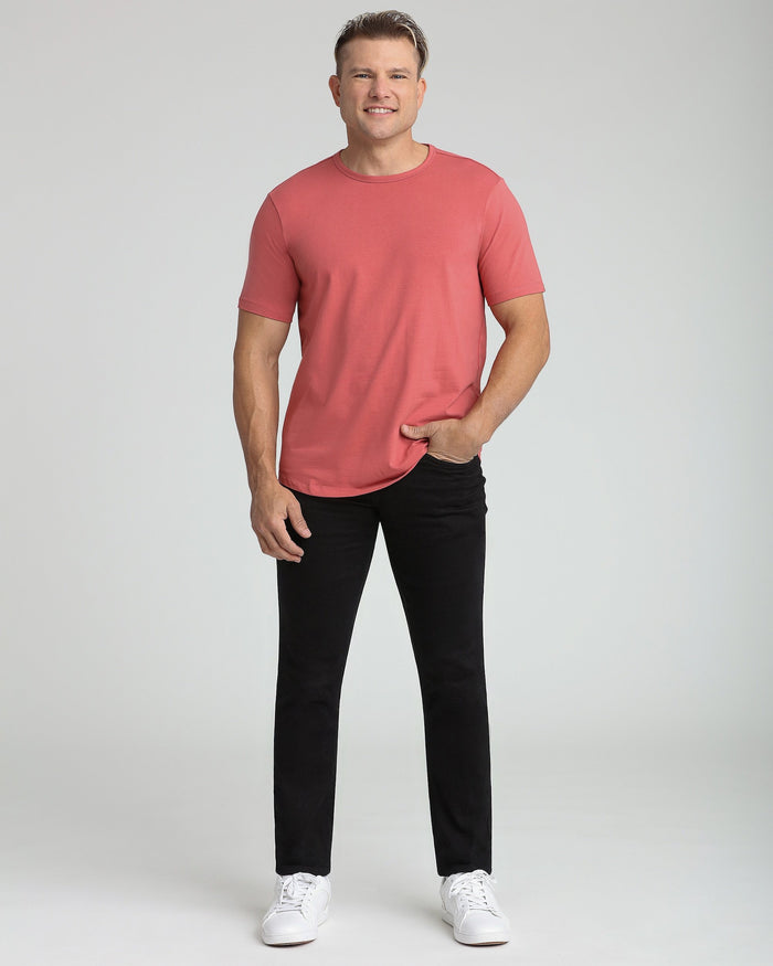 Man wearing Nantucket red crew neck t-shirt with black pants and white sneakers.