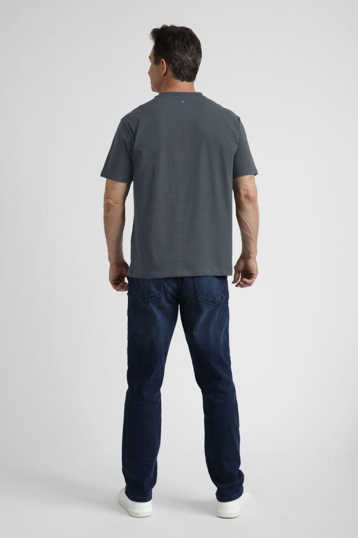 Man wearing steel gray crew neck t-shirt and dark blue jeans, shown from back.