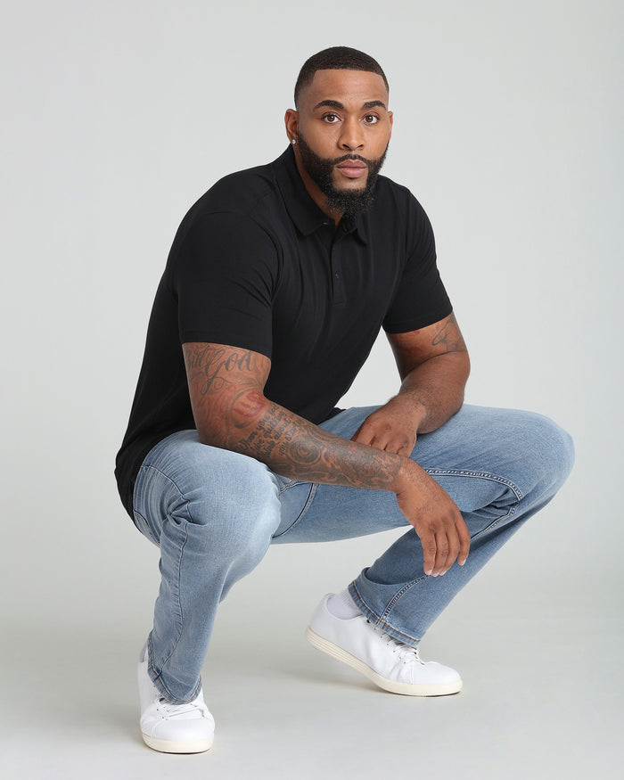 Black polo shirt with short sleeves and button front collar, worn by male model.