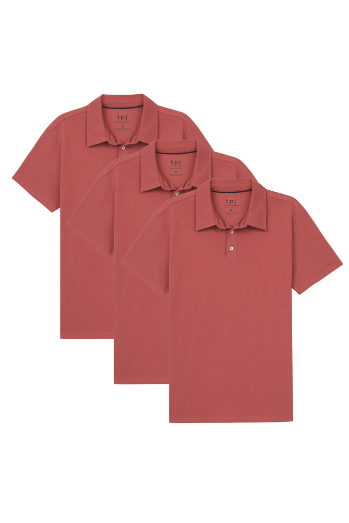 Three nantucket red polo shirts with short sleeves and button plackets displayed in graduated sizes.