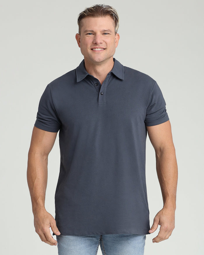 Man wearing navy blue short-sleeve polo shirt with collar and button placket, paired with light blue jeans.