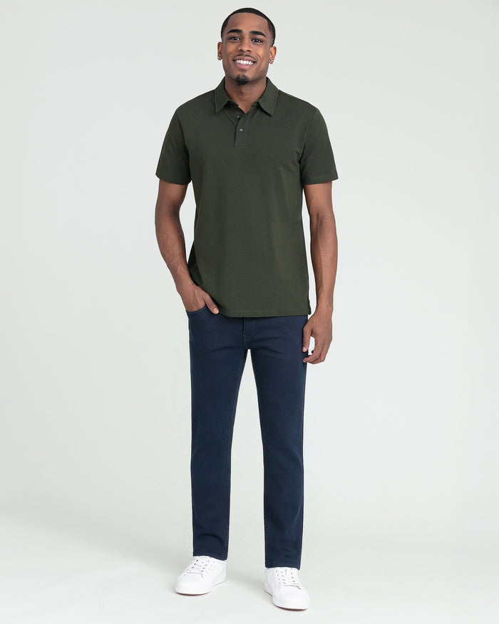 Man wearing olive short-sleeve polo shirt with button placket and dark navy jeans.
