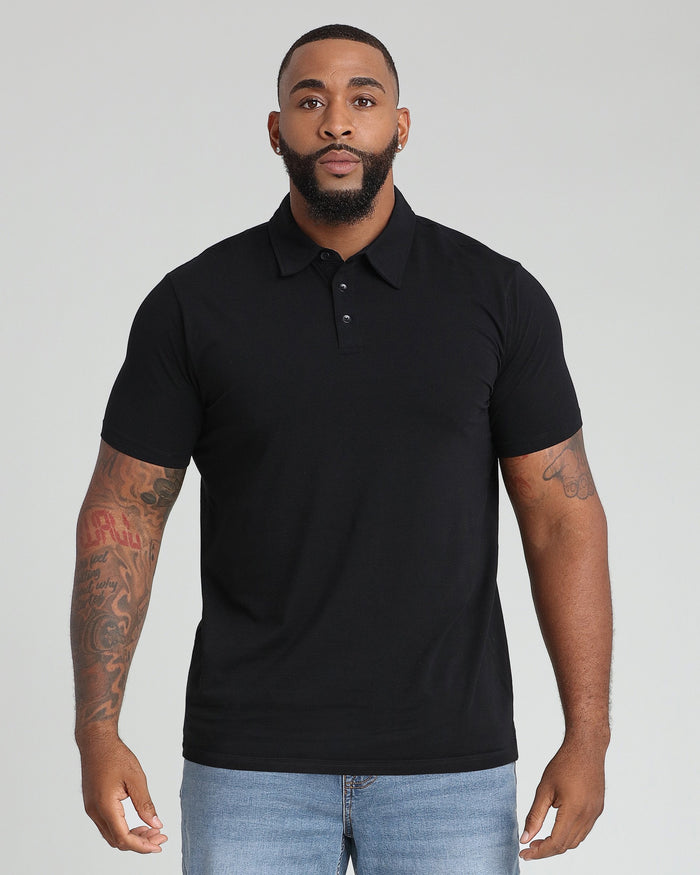 Black polo shirt with collar and button placket, short sleeves, worn with light blue jeans.