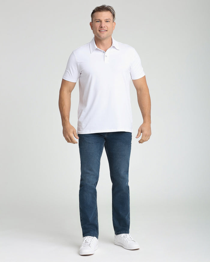 Man wearing white short-sleeve polo shirt with collar and button placket, paired with dark blue jeans.