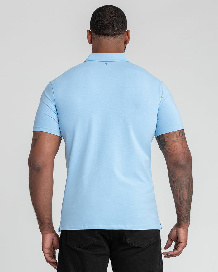Light blue polo shirt with collar, shown from back view on male model wearing black pants.
