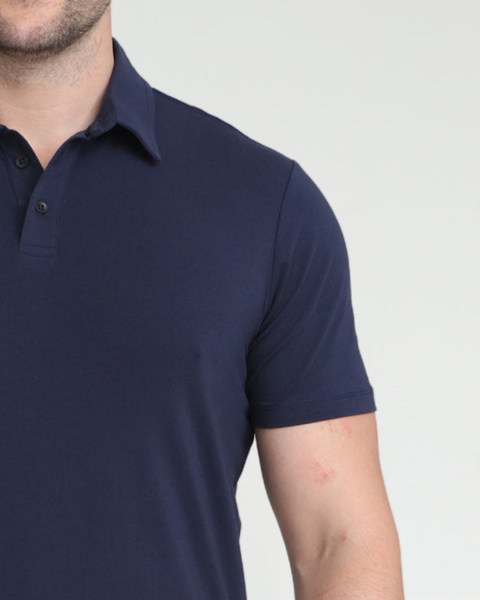 Man wearing navy polo shirt with collar and button placket.