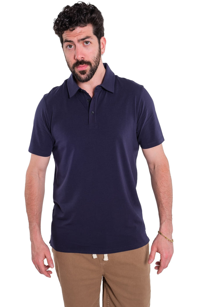 Man wearing navy short-sleeve polo shirt with collar and button placket, paired with tan pants.