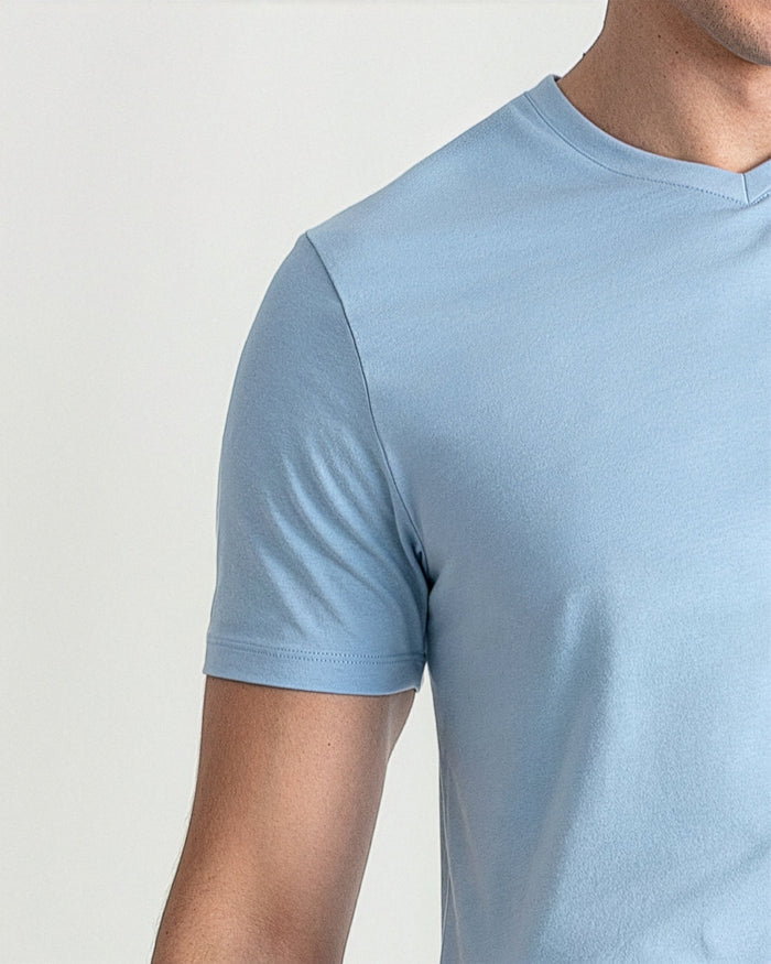 Light blue V-neck t-shirt with short sleeves on a male model against a white background.