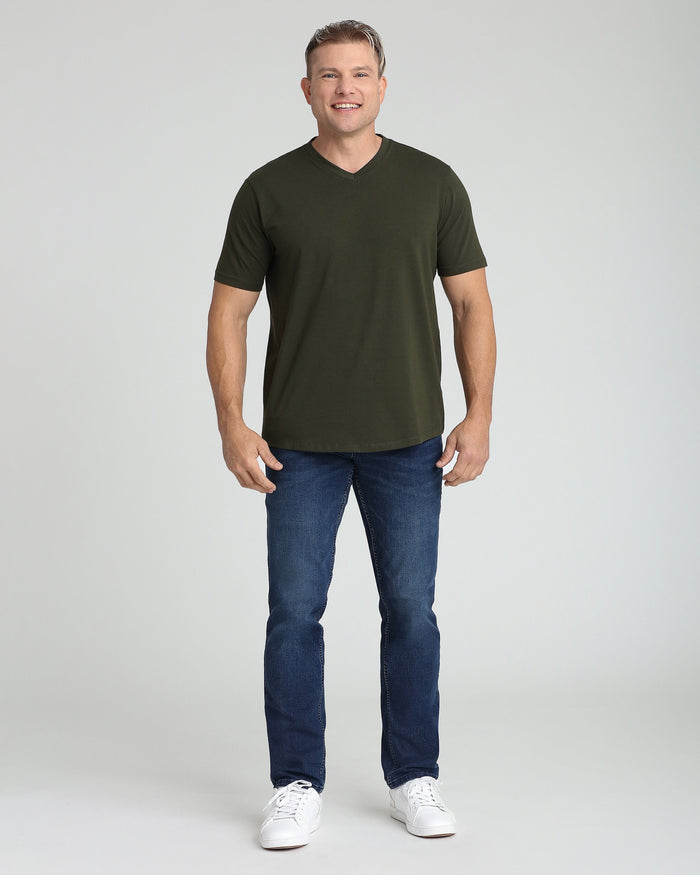 Man wearing olive v-neck t-shirt with short sleeves and blue jeans.