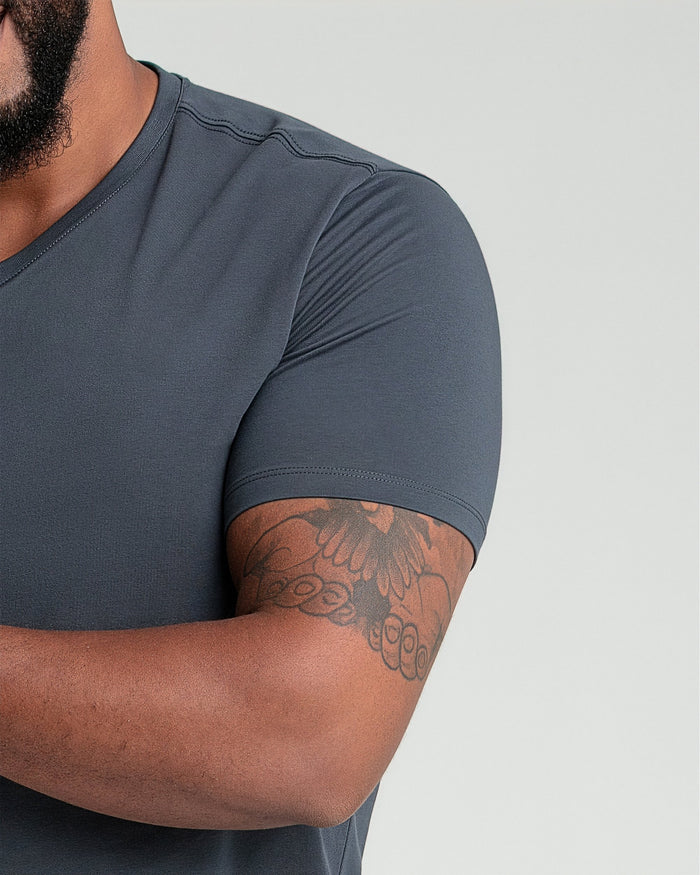 Man wearing steel gray v-neck t-shirt with short sleeves, shown from shoulder to mid-torso.