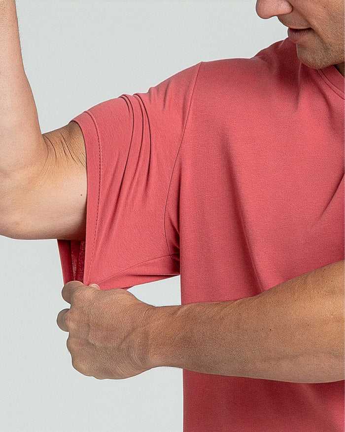 Man wearing nantucket red v-neck t-shirt with short sleeves against white background.