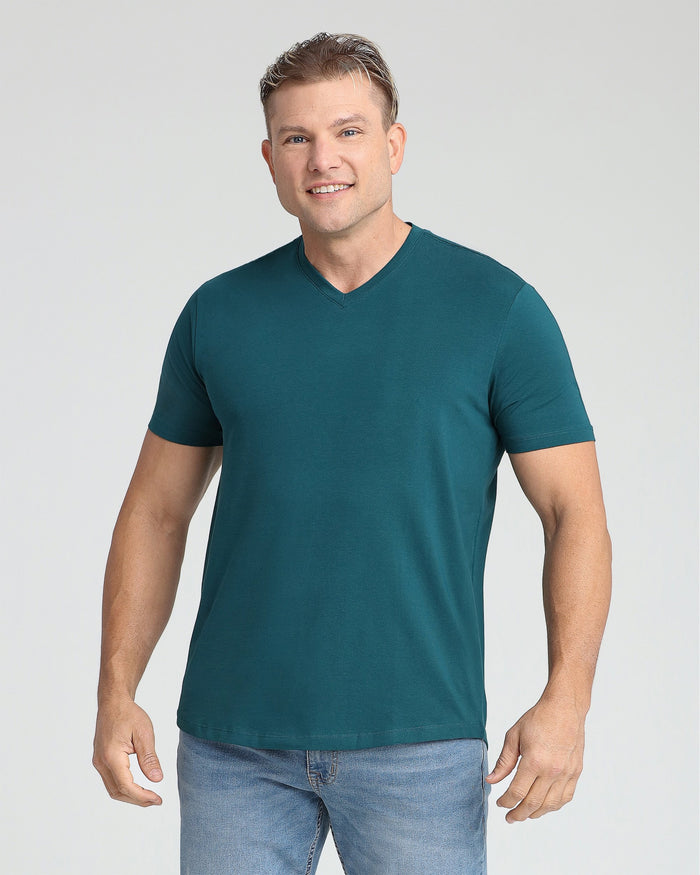 Man wearing teal V-neck short-sleeve t-shirt paired with light blue jeans.