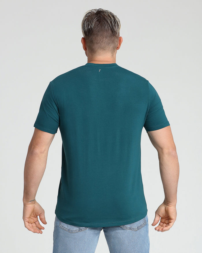 Man wearing teal v-neck t-shirt, back view, paired with light blue jeans.