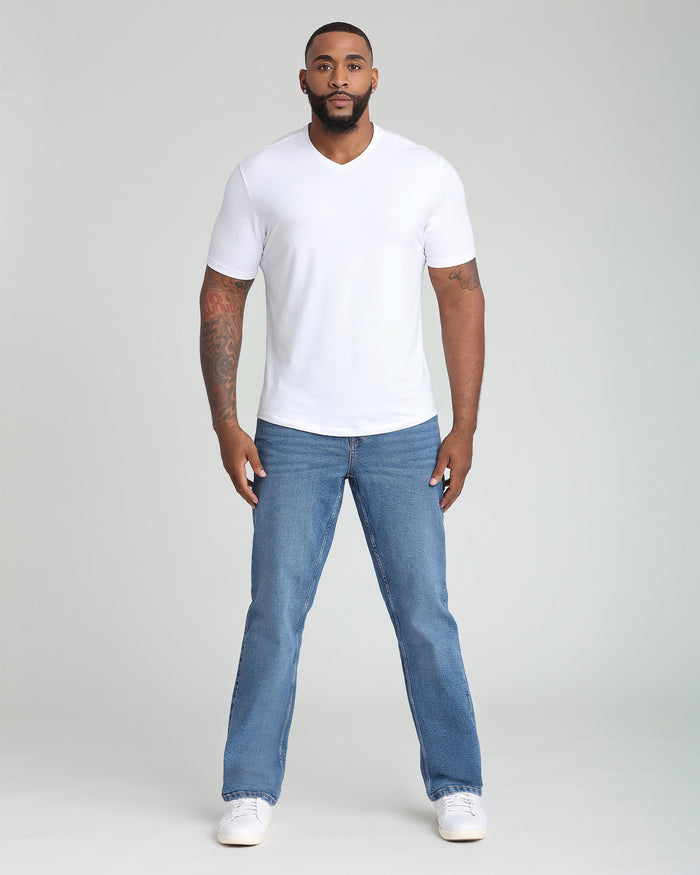 Man wearing white v-neck short-sleeve t-shirt and blue jeans.